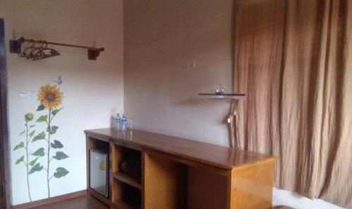 a room with a desk with a flower on the wall at Trinity Family Inn in Nyaung Shwe