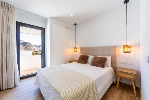 a bedroom with a bed and a large window at TrendyHomes San Jose in San José