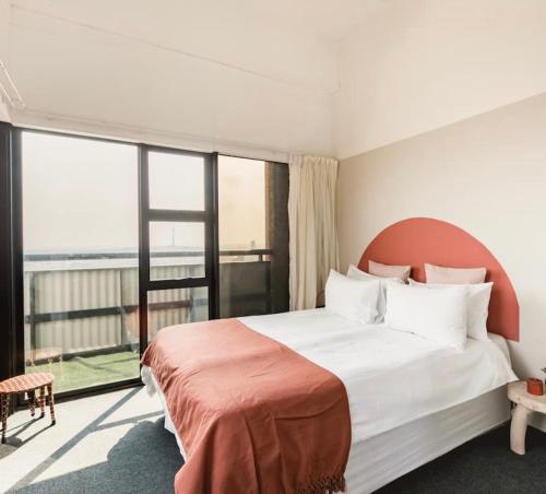 a bedroom with a large bed and a large window at COGE - Braamfontein - 2 Bedroom in Johannesburg