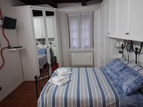 sypialnia z łóżkiem z niebiesko-białymi paskami w obiekcie Il Sasso appartamento w mieście Orta San Giulio