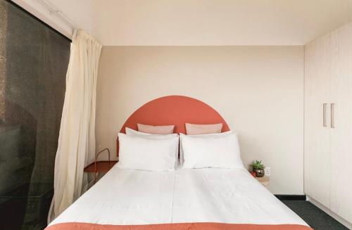 a bedroom with a white bed with a red headboard at COGE - Braamfontein - 2 Bedroom in Johannesburg