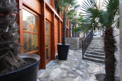a building with a staircase and palm trees in a courtyard at Palm Tbilisi Boutique Hotel in Tbilisi City