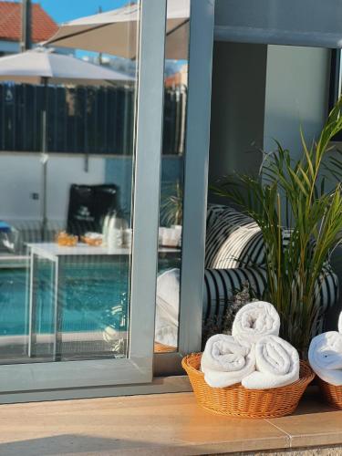 two baskets of towels sitting next to a pool at Villa Caparica Hostel in Costa da Caparica