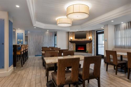 a dining room with tables and chairs and a fireplace at Holiday Inn Express Tallahassee by IHG in Tallahassee