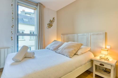 une chambre avec un lit blanc avec une fenêtre dans l'établissement Justin charme à Rouen avec parking sécurisé, à Rouen