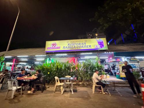 a group of people sitting at tables outside a restaurant at NEW Bangsar Trade Centre KL Mid Valley LRT Bangsar in Kuala Lumpur