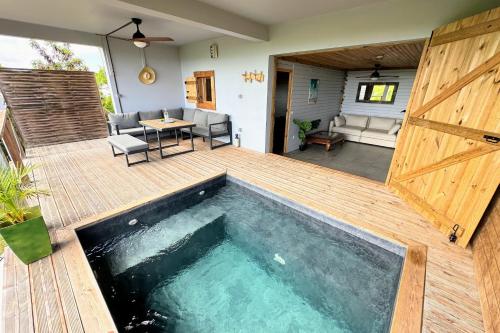 una piscina en una terraza con puerta de madera en Bungalow Cosy, en Grand-Bourg
