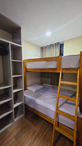 a bedroom with two bunk beds and shelves at Apart VIP PIURA Aire Acondicionado-Estacionamiento in Piura