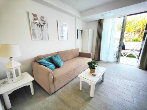 a living room with a couch and a table at Prime garden-view Studios in Arona