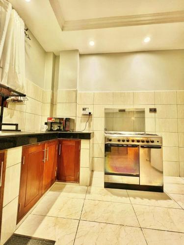 a kitchen with wooden cabinets and a stove top oven at Shanzu Oceanfront Apartments and Suites in Mombasa