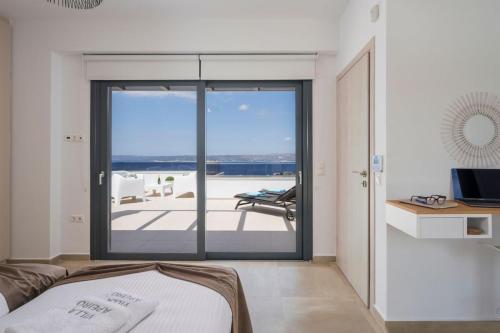 a bedroom with a sliding glass door to a patio at Luxury Villa Apeiro in Plaka in Plaka