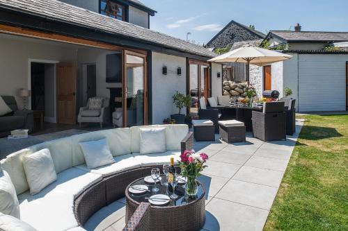 a patio with a couch and a table with flowers at Y Gorlan - Snowdonia luxury house Carneddau mountain views in Conwy