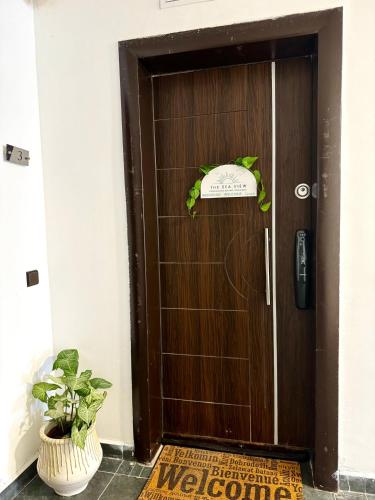 a wooden door with a plant in front of it at sea view apartment in Tangier