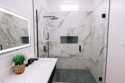 Un baño blanco con ducha y lavabo. en Magic canal, en Nueva Orleans