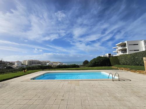 a swimming pool in a patio with a building at Blue Beach by ACasaDasCasas in Ericeira
