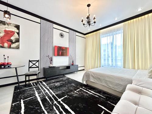 a bedroom with a bed and a table and a chair at Apart Complex Meridian из 10 отдельных апартаментов рядом с Арбатом in Almaty