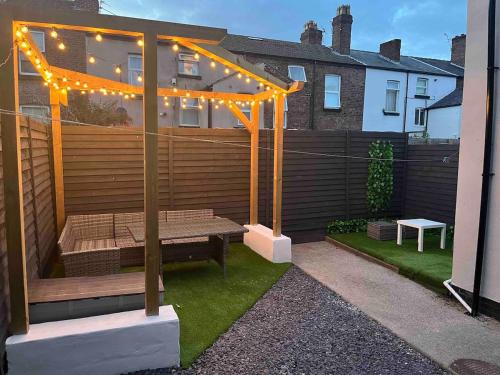 a patio with a bench under a pergola with lights at Flat3 large modern king Bed flat private bathroom ryan's place in Walton on the Hill
