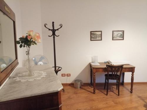 a room with a desk and a vase of flowers on a table at B&B Leon D'Oro in Pusiano