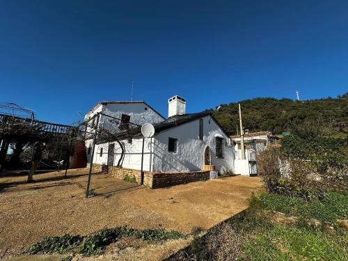 a white house on the side of a hill at Bonita Casa Rural Sierra Norte in El Pedroso
