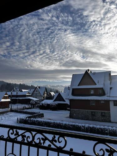 a view from a balcony of snow covered houses at Pokoje z własnymi aneksami kuchennymi - Zbigniew Lassak in Biały Dunajec