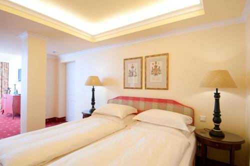 two beds in a room with two lamps at Hotel City House in Hamburg