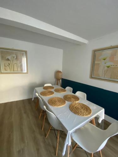 Cette chambre comprend une table blanche avec des chaises et des biscuits. dans l'établissement Authentique maison de pêcheur à Port-en-Bessin, à Port-en-Bessin-Huppain