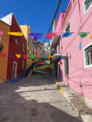 a street with colorful buildings and a colorful staircase at Casa Angelitos in Guanajuato