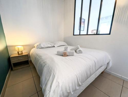 une chambre avec un lit avec deux serviettes dessus dans l'établissement Apparemment moderne au cœur de Bayonne, à Bayonne