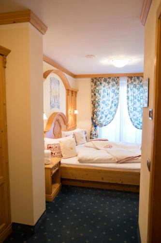 a hotel room with a bed and a window at Hotel Gianna in Madonna di Campiglio