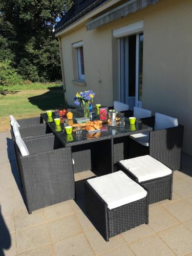 a table and chairs with food on a patio at Venez vous ressourcer au calme in Locmaria-Grand-Champ