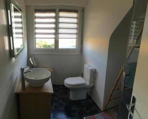 a bathroom with a toilet and a sink and a window at Venez vous ressourcer au calme in Locmaria-Grand-Champ