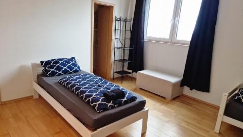 ein Schlafzimmer mit einem Bett mit blauen Kissen und einem Fenster in der Unterkunft 8-10 Personen Maisonette Wohnung mit 3,5 Schlafzimmern in Wörrstadt
