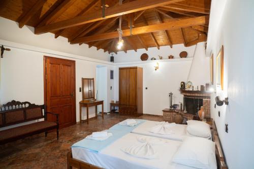 a bedroom with a large bed and a fireplace at Giannakos Apartments in Ydroússa