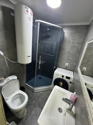 a bathroom with a shower and a toilet and a sink at 3ком люкс в центре города in Karagandy