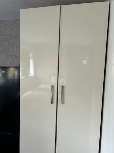 a white cabinet with two doors in a room at NICE HOUSE Families contractors in Birmingham