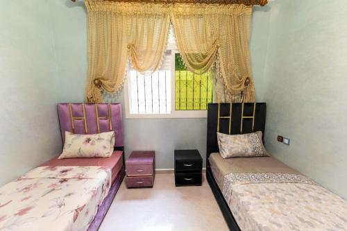 a bedroom with two beds and a window at Appartement Saphir à Fès - Calme & Coloré in Fès