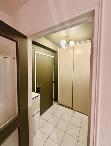 un couloir avec des murs verts et une porte vers une salle de bain dans l'établissement Le Croix-Roussien - Apartment 30m2, à Caluire-et-Cuire