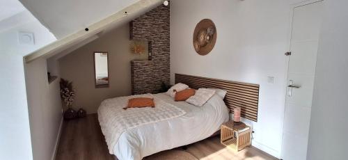 a bedroom with a bed and a brick wall at Gite La maison du 37 avec terrasse et jardinet in Breteil