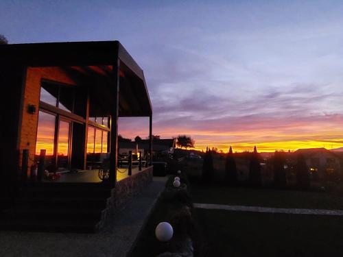 a building with a sunset in the background at Balada dintre dealuri - Casa Soarelui si Casa Lunii in Cisnadioara