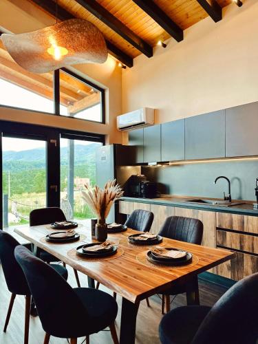 a kitchen with a wooden table and chairs at Balada dintre dealuri - Casa Soarelui si Casa Lunii in Cisnadioara