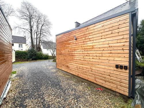 a wooden retaining wall next to a driveway at Refuge des voyageurs - Studio neuf - Rivage indépendant en rez de jardin in Plouédern