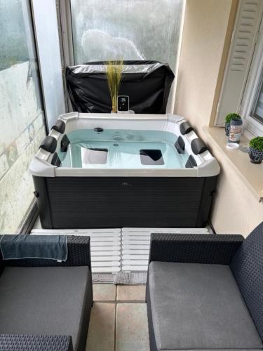 a hot tub in a room with two chairs at Jolie Villa indépendante climatisée 3 chambres tout confort 6 couchages, piscine chauffée 4 X 8 disponible selon météo de Mai à fin Septembre, Jacuzzi 4 places, boulodrome éclairé, ping-pong, wifi, proche commerces Animaux domestiques sur demande in Bretenoux