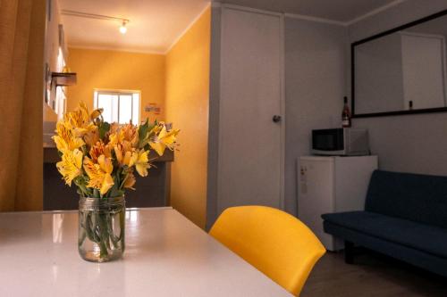 a vase of yellow flowers sitting on a table at Casa Samaykuy in Ayacucho