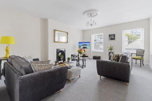 a living room with couches and chairs and a fireplace at The Heart of Brixham, Bolton Plaice, Luxury Apartment in Brixham