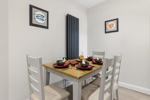 a dining room table and chairs with food on it at The Heart of Brixham, Bolton Plaice, Luxury Apartment in Brixham