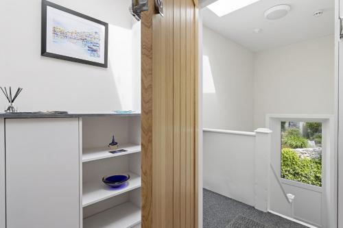 a room with white walls and white shelves at The Heart of Brixham, Bolton Plaice, Luxury Apartment in Brixham