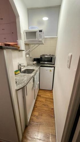 a small kitchen with a sink and a microwave at Frente a la Playa Pocitos! in Montevideo