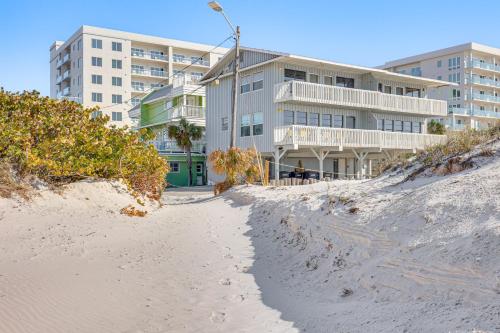 a building sitting on top of a sandy beach at Driftwood Beach Suite - Walk to Clearwater Bch in Clearwater Beach