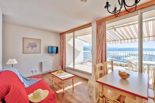 un salon avec une table et une grande fenêtre dans l'établissement Résidence Bandol Port, à Bandol
