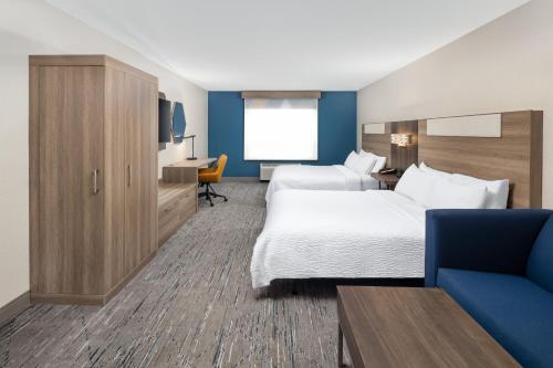 a hotel room with two beds and a couch at Holiday Inn Express & Suites - Green Bay East by IHG in Green Bay